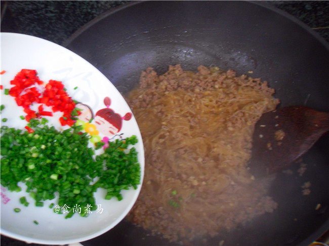 蚂蚁上树,接着倒入泡软的粉条,调入<a style='color:red;display:inline-block;' href='/shicai/ 692'>酱油</a>,翻炒至粉条吸足汤汁,撒下葱花和辣椒碎