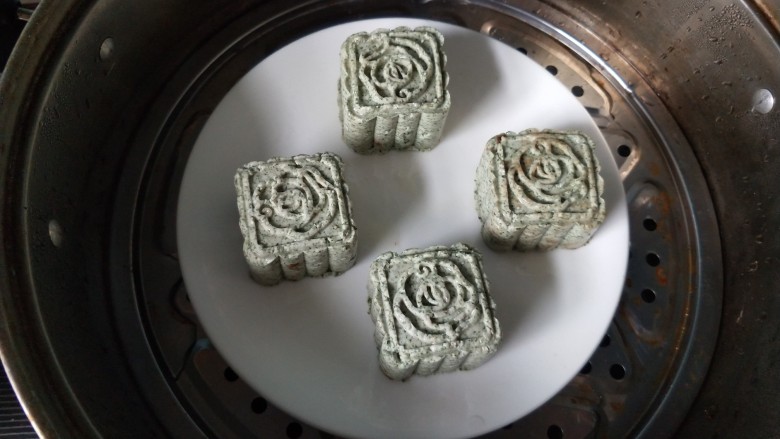艾叶豆沙青团(月饼模具版),将做好的艾团放入蒸锅,大火蒸20分钟!这是又做了另外一个花型的艾团。