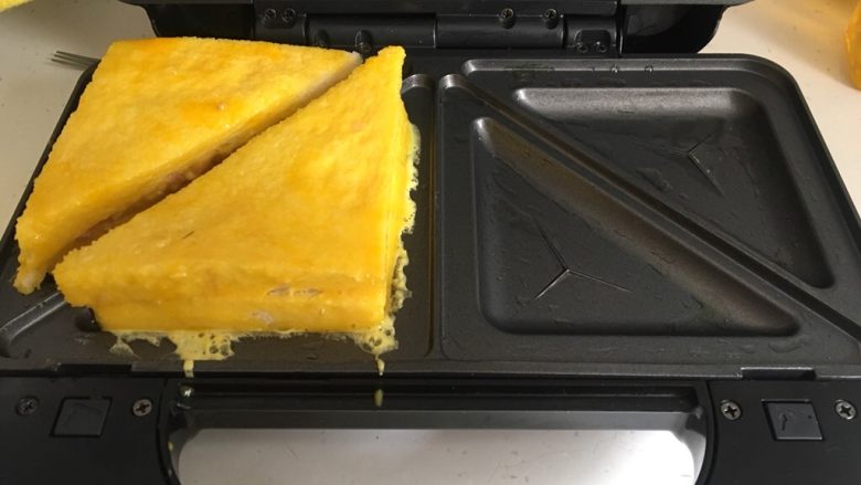 三明治蛋糕机版,把切好的三明治所有面都裹上蛋液,如图放入蛋糕机