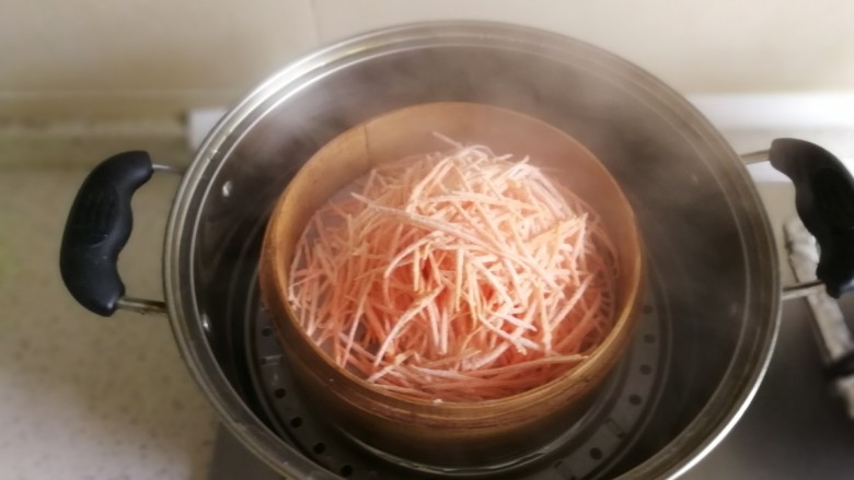 蒸胡萝卜丝,水开后上笼蒸,一定记住要水开后才能放入锅中。一根胡萝卜的话就六分钟就可以了,记住不要多蒸,六分钟就可以了。