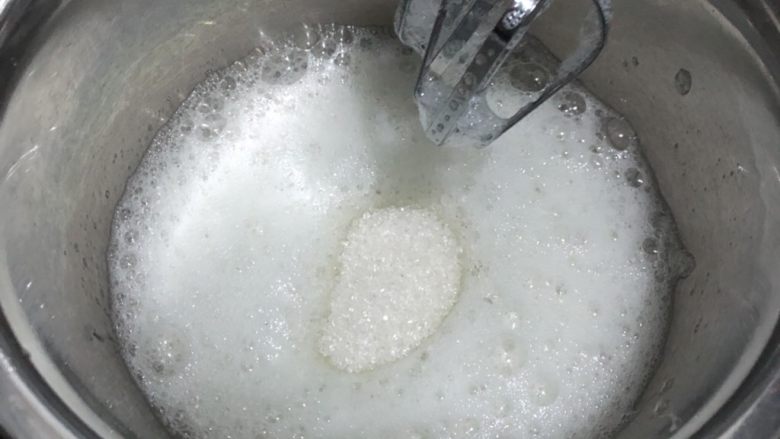 橘香戚风蛋糕,蛋白打发,滴入一滴白醋,白砂糖50g分三次加入,首先打发至粗泡状,加第一次糖,打发;加第二次糖,打发;加第三次糖,打发