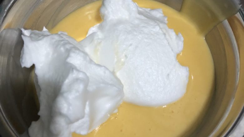 橘香戚风蛋糕,将三分之一蛋白加入蛋黄糊,翻拌均匀;再取剩余蛋白一半加入蛋黄糊,翻拌均匀
