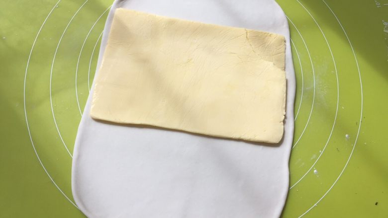 棒棒糖苹果派,冰箱取出冷冻的黄油片,裁掉保鲜袋,铺在面片中间