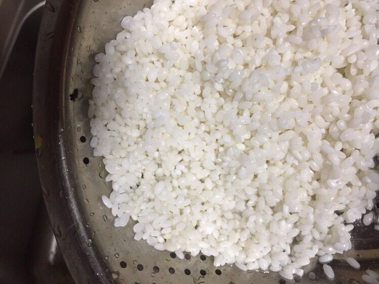 糯小米蒸排骨,浸泡好的糯米沥干水分,此时可以准备蒸锅加入水烧水了