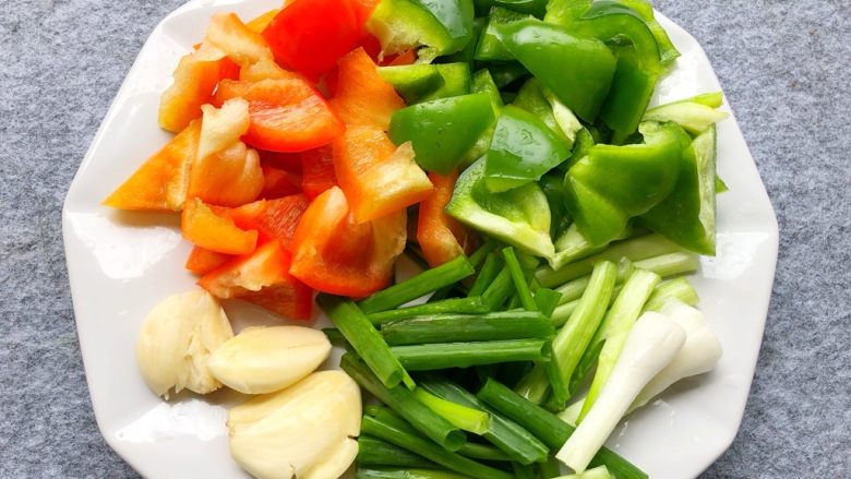 家常豆腐,青红椒洗净去籽切块，葱洗净切长段，蒜去皮拍扁待用