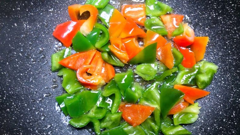 家常豆腐,锅里剩底油，放入青红椒翻炒至断生，盛出待用