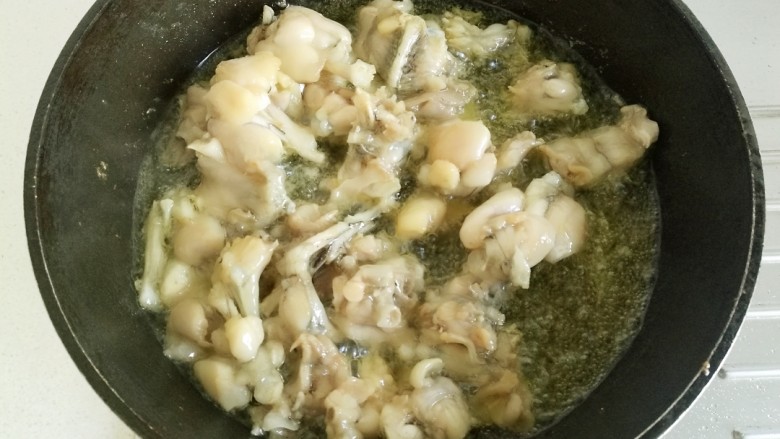 干锅牛蛙,直到牛蛙看起来肉质变紧,微微发黄即可捞出控油。