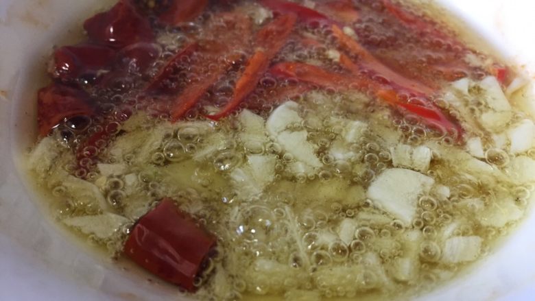 麻辣金针菇,把椒油直接浇入碗中爆香蒜辣椒