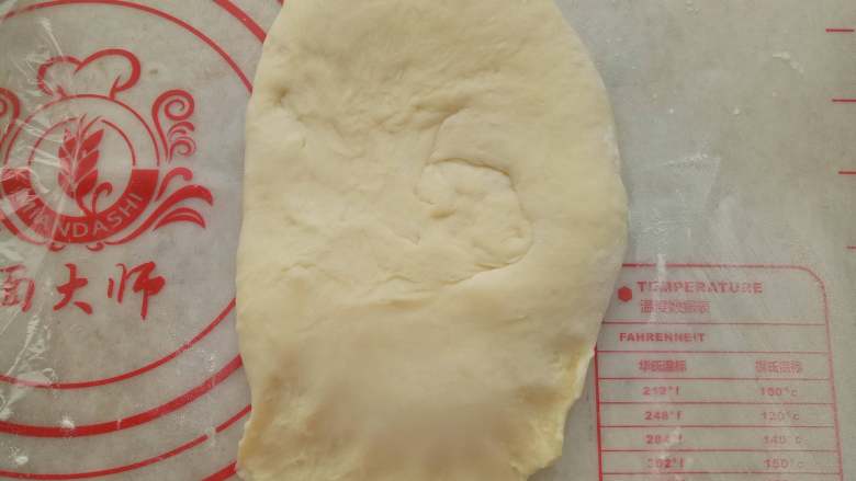 千层汉堡,取一份面团擀成牛舌形，然后卷起来。