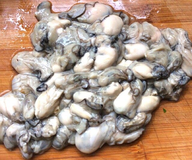 海蛎子韭菜白玉菇饺子,捞出沥干,放案板上用刀揽几下,不要切太碎,放入盆中