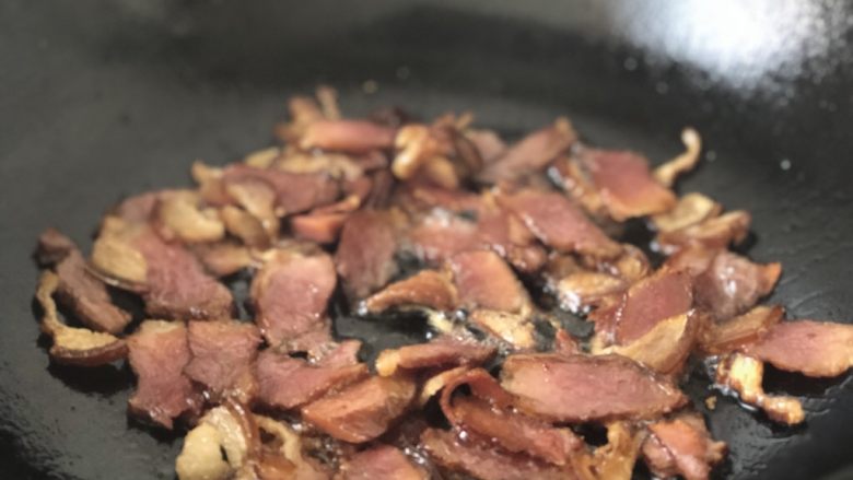 春笋炒腊肉,热锅,倒入适量油,放入腊肉煸炒出油。