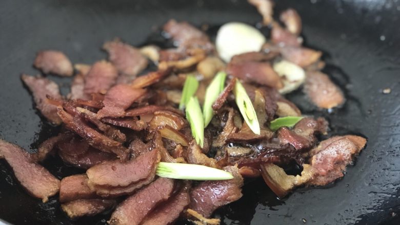 春笋炒腊肉,加入青蒜苗,翻炒几下。