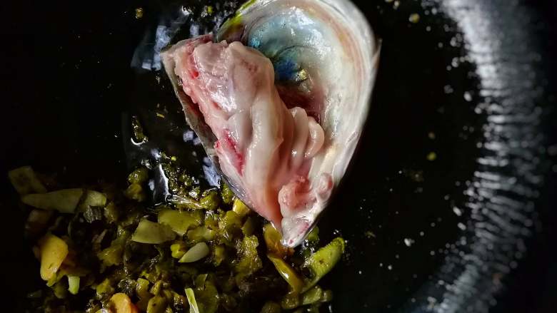 香锅酸菜鱼,炒好的酸菜料搁置一边,下鱼头