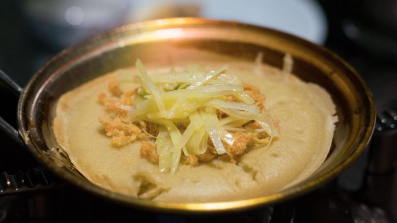 成都美食蛋烘糕,关于蛋烘糕制作流程:1,称好低筋粉,放入碗中。然后加入酵母粉。然后把鸡蛋打散搅拌均匀也倒入碗中。2,用40克温水融化白糖和红糖,然后倒入碗中。3,再加40克到60克左右的温开水(加上红糖的水,一共就是80到100克。具体量还得看面粉的吸水性,慢慢添加,感觉很粘稠刚好能流动就行。)慢慢倒入碗中。慢慢搅拌,再加入色拉油,继续搅拌,最终使面糊能挂在筷子上,一定是比较粘稠的感觉才行。4, 放置两个多三小时后(三个小时只是平均值,夏天30度左右,需要发酵一个多两个小时,冬季五度左右,大约需要6七个小时或者更久。春秋季节差不多三个小时左右。具体时间观察面糊,面糊如果变来膨胀起来,很多蜂窝状或者气泡。那就说明发酵好了。),发酵好了。然后加入小苏打,盐和香精(商用,自己吃可以不添加),继续搅拌至出现许多小气泡则完成了面液。--5, 烘烤面皮: 铜锅上炉子,开中火。五六秒后用夹子夹着一块沾有油的棉布擦上薄薄的一层油(植物油都可以,比如调和油,菜籽油,花生油,大豆油)在整个锅上,包括边缘。,6, 等两三秒秒后用汤勺盛面液入锅中,摇晃锅使面液铺均匀,锅边缘处也铺上,这样边缘也就薄脆了。7,盖上盖子,等七八秒后改最小火烘烤,等面皮烘干。8, 观察面液干掉后,立刻加入内陷,盖盖子再等几秒,这时是在加热内陷。9, 用夹子对折面皮后立刻起锅。