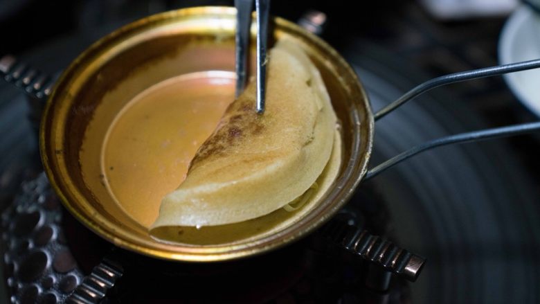 成都美食蛋烘糕,关于蛋烘糕制作流程:1,称好低筋粉,放入碗中。然后加入酵母粉。然后把鸡蛋打散搅拌均匀也倒入碗中。2,用40克温水融化白糖和红糖,然后倒入碗中。3,再加40克到60克左右的温开水(加上红糖的水,一共就是80到100克。具体量还得看面粉的吸水性,慢慢添加,感觉很粘稠刚好能流动就行。)慢慢倒入碗中。慢慢搅拌,再加入色拉油,继续搅拌,最终使面糊能挂在筷子上,一定是比较粘稠的感觉才行。4, 放置两个多三小时后(三个小时只是平均值,夏天30度左右,需要发酵一个多两个小时,冬季五度左右,大约需要6七个小时或者更久。春秋季节差不多三个小时左右。具体时间观察面糊,面糊如果变来膨胀起来,很多蜂窝状或者气泡。那就说明发酵好了。),发酵好了。然后加入小苏打,盐和香精(商用,自己吃可以不添加),继续搅拌至出现许多小气泡则完成了面液。--5, 烘烤面皮: 铜锅上炉子,开中火。五六秒后用夹子夹着一块沾有油的棉布擦上薄薄的一层油(植物油都可以,比如调和油,菜籽油,花生油,大豆油)在整个锅上,包括边缘。,6, 等两三秒秒后用汤勺盛面液入锅中,摇晃锅使面液铺均匀,锅边缘处也铺上,这样边缘也就薄脆了。7,盖上盖子,等七八秒后改最小火烘烤,等面皮烘干。8, 观察面液干掉后,立刻加入内陷,盖盖子再等几秒,这时是在加热内陷。9, 用夹子对折面皮后立刻起锅。