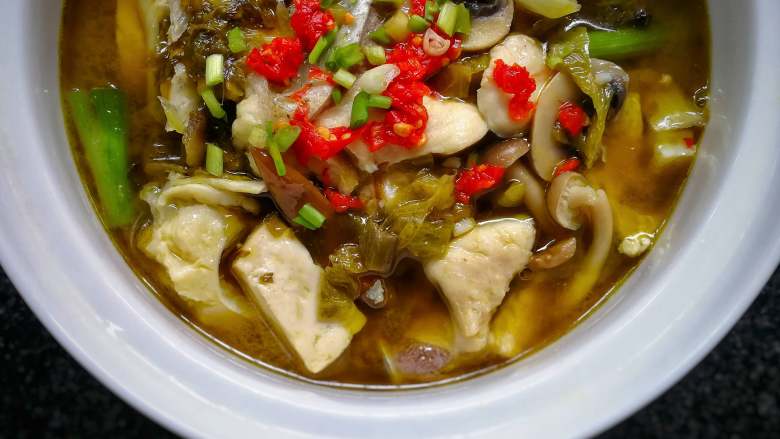 香锅酸菜鱼,待熟后装盛入器,撒下红泡椒碎和<a style='color:red;display:inline-block;' href='/shicai/ 3232'>香葱</a>粒。