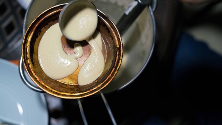 成都美食蛋烘糕,关于蛋烘糕制作流程:1,称好低筋粉,放入碗中。然后加入酵母粉。然后把鸡蛋打散搅拌均匀也倒入碗中。2,用40克温水融化白糖和红糖,然后倒入碗中。3,再加40克到60克左右的温开水(加上红糖的水,一共就是80到100克。具体量还得看面粉的吸水性,慢慢添加,感觉很粘稠刚好能流动就行。)慢慢倒入碗中。慢慢搅拌,再加入色拉油,继续搅拌,最终使面糊能挂在筷子上,一定是比较粘稠的感觉才行。4, 放置两个多三小时后(三个小时只是平均值,夏天30度左右,需要发酵一个多两个小时,冬季五度左右,大约需要6七个小时或者更久。春秋季节差不多三个小时左右。具体时间观察面糊,面糊如果变来膨胀起来,很多蜂窝状或者气泡。那就说明发酵好了。),发酵好了。然后加入小苏打,盐和香精(商用,自己吃可以不添加),继续搅拌至出现许多小气泡则完成了面液。--5, 烘烤面皮: 铜锅上炉子,开中火。五六秒后用夹子夹着一块沾有油的棉布擦上薄薄的一层油(植物油都可以,比如调和油,菜籽油,花生油,大豆油)在整个锅上,包括边缘。,6, 等两三秒秒后用汤勺盛面液入锅中,摇晃锅使面液铺均匀,锅边缘处也铺上,这样边缘也就薄脆了。7,盖上盖子,等七八秒后改最小火烘烤,等面皮烘干。8, 观察面液干掉后,立刻加入内陷,盖盖子再等几秒,这时是在加热内陷。9, 用夹子对折面皮后立刻起锅。
