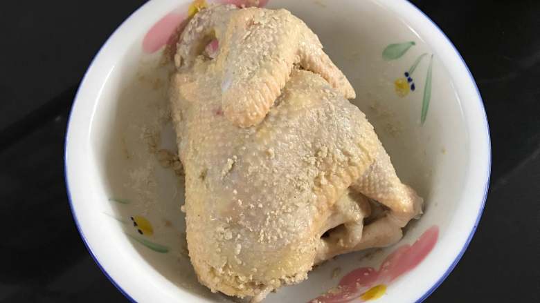 砂锅烤窑鸡,然后把混合好的沙姜盐均匀地抹在鸡身上,里面也上抹上。