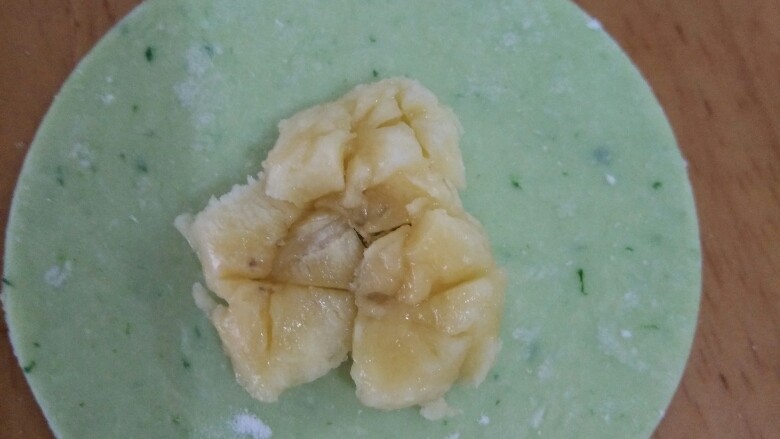 绿色香蕉馅饼,用勺子压一下,然后周围抹一圈清水。