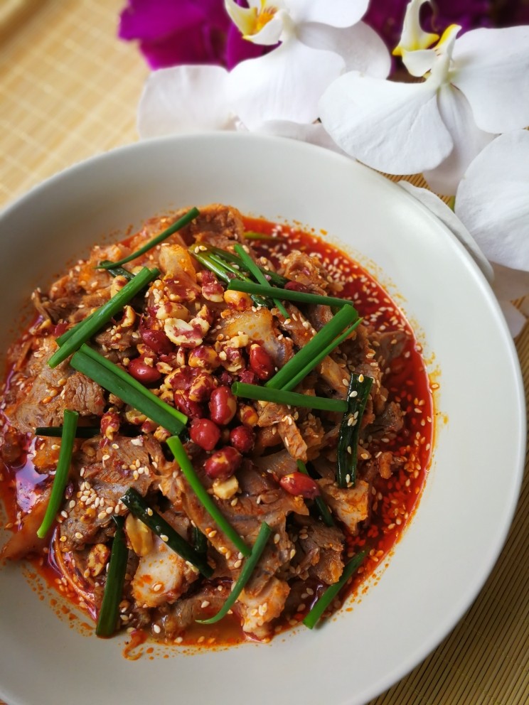 川味凉拌拆骨肉,将切好的猪头肉放入调料汁里拌匀，装盘后撒上油炸花生米就可以上桌了。