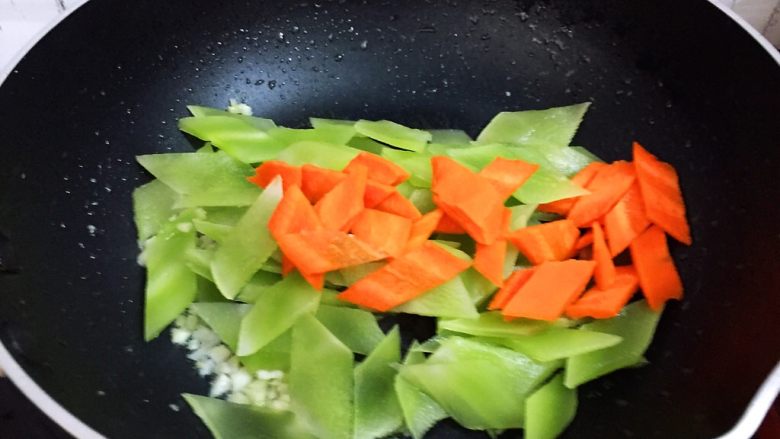 莴笋炒肉,放入莴笋和胡萝卜,翻炒至断生