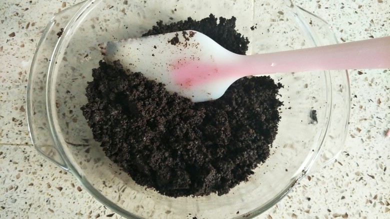 芒果慕斯,然后把黄油倒入饼干碎里面拌匀,一定要充分拌匀,饼干碎是靠黄油凝固的