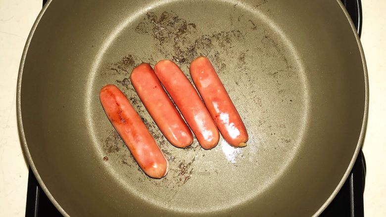 5分钟快手菜 烤肠三明治,把烤肠放入锅中小火煎制,煎至两面变色即可