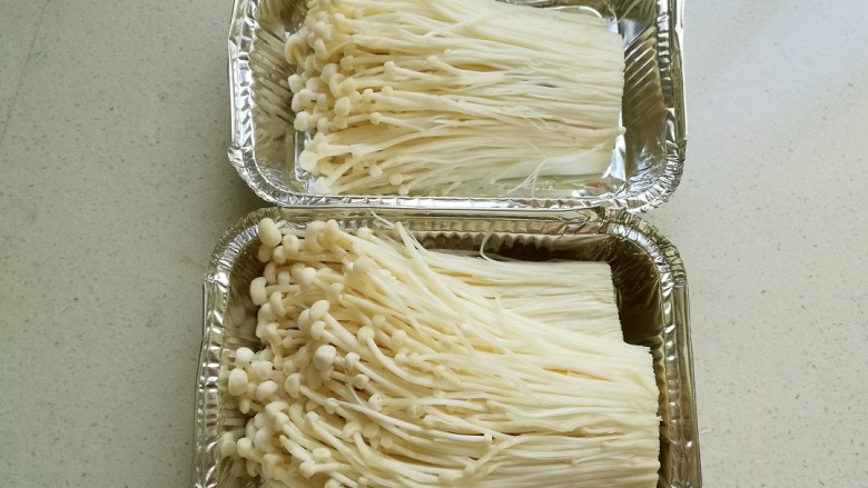 蒜蓉豉油金针菇,然后把金针菇分层放进锡纸盒中,锡纸盒一个嫌小,我放进二个锡纸盒中。