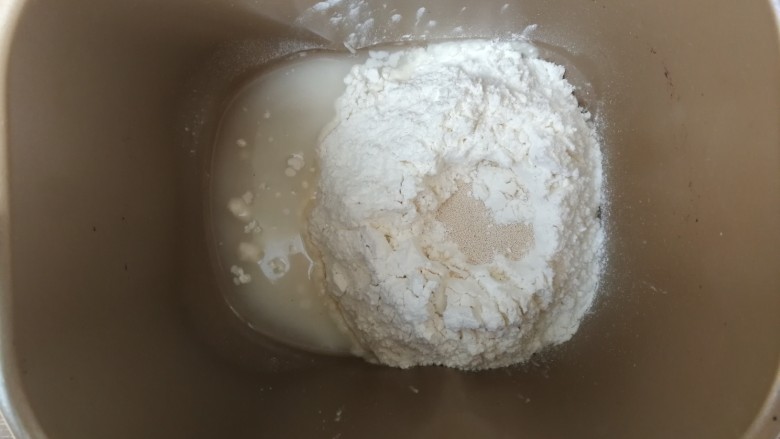 薄底香肠披萨,除黄油和盐外,面团材料按照先液体后粉类的顺序依次投入面包机桶,干酵母在面粉中间挖一个坑填入