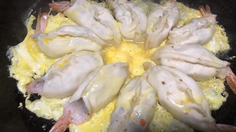美味虾蛋报饺,一个鸡蛋打散,缓慢倒入锅中,让鸡蛋均匀的包住虾饺