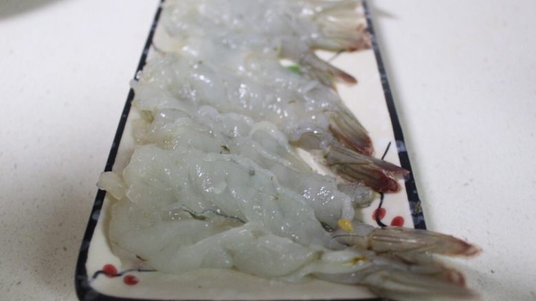 美味虾蛋报饺,将海虾从背部切开,不要切断,去掉虾线和虾泥,再用刀背将海虾背轻拍2下,这样是为了将虾筋拍断,这样不会卷曲