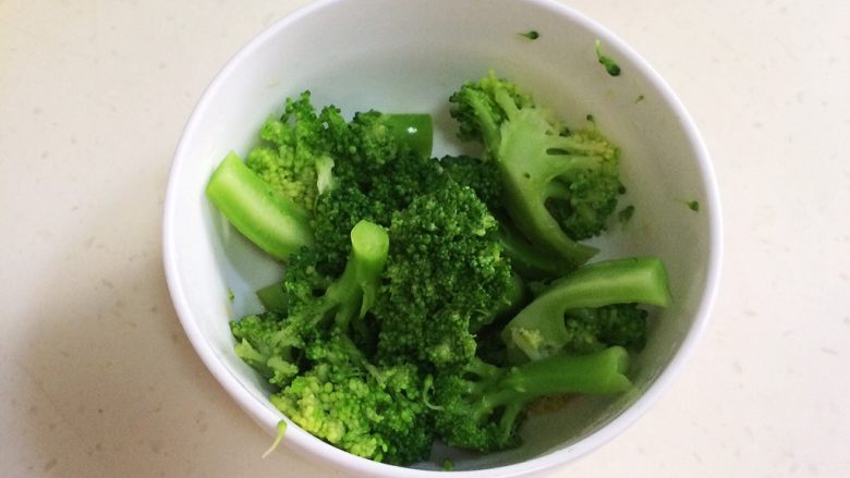鲜虾时蔬饭团便当,煮好的西兰花放入小碗中,加入1小匙蒸鱼鼓油拌匀。