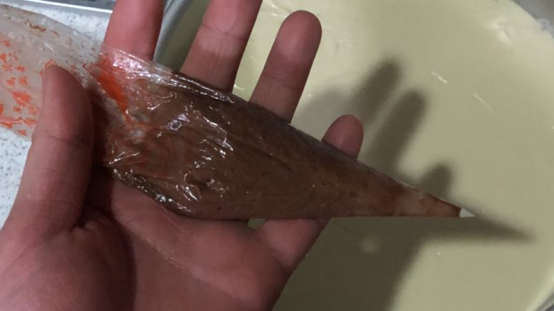 布朗尼芝士蛋糕,黑白蛋糕糊个留10g,裱花袋中混合均匀,剪一小口即可