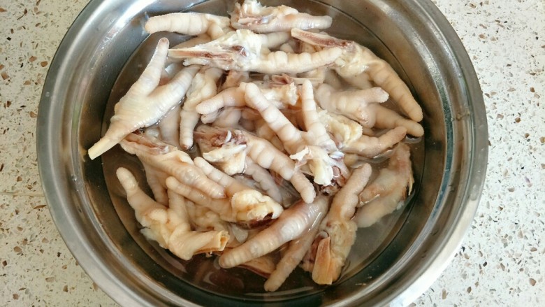 柠香泡椒凤爪,煮熟的鸡爪过一遍冷水,洗掉浮沫,泡在冰水里(水是开水烧开放凉的,不能是自来水)