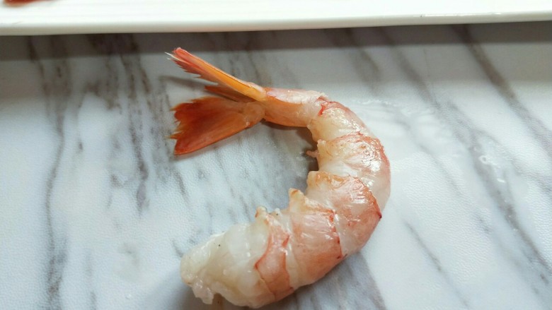#辅食计划#黄金凤尾虾#煮蛋器版#,去除虾线后再将阿根廷红虾尾去皮。切记(虾尾要留下虾尾要留下,虾尾要留下)重要的事情说三遍!如图,依次将阿根廷红虾处理好。