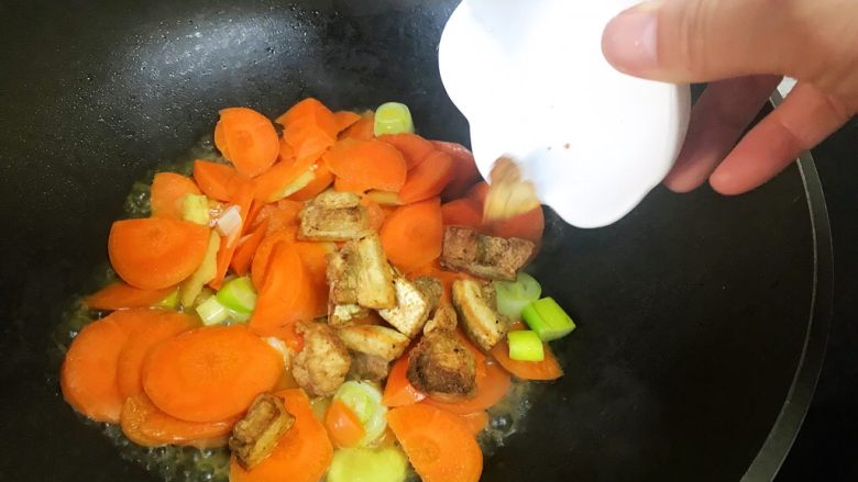 油梭子炒胡萝卜,加入油梭子继续翻炒，调入少许水