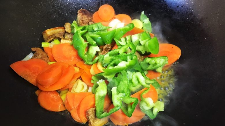 油梭子炒胡萝卜,加入青椒翻炒