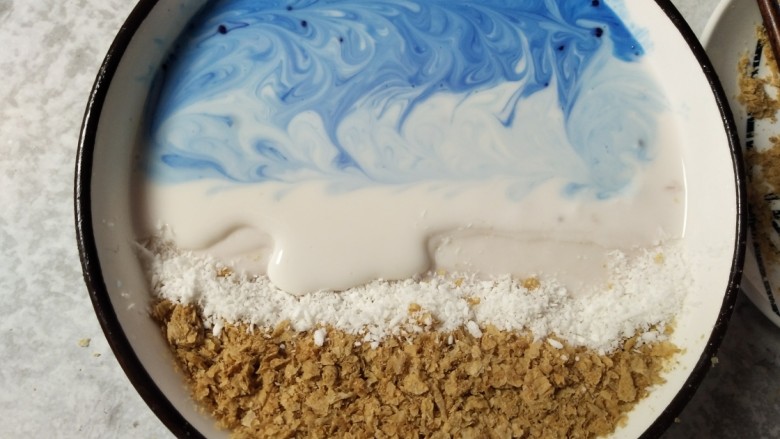 海洋世界~Smoothie bowl,在碗的燕麦这一边底下垫高,低处倒入酸奶,并放入藻蓝蛋白,要分次放入,靠近碗边的多放两次,拉出花和层次。