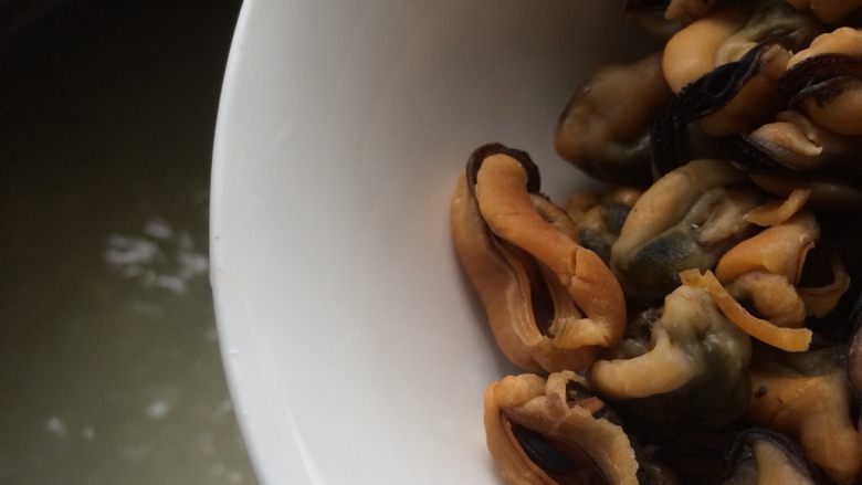 皮蛋淡菜瘦肉粥,用砂锅煮粥,米煮开后倒入淡菜,大火煮开关火焖煮。