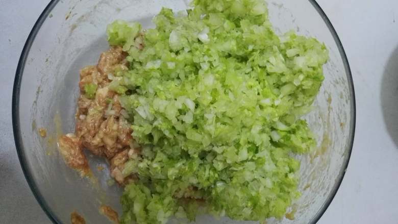 亦饭亦菜+美味+猪肉白菜包,将白菜加入,也要用顺时针的搅拌方法将白菜与肉馅拌匀。