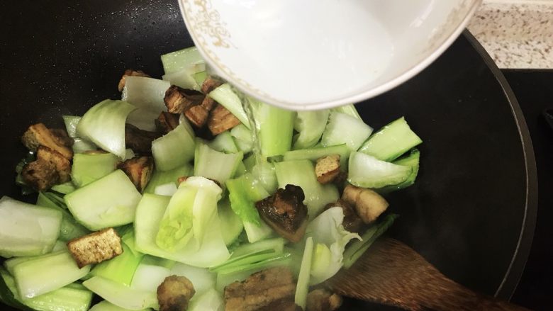 青菜炒油梭子,调入少许水翻炒