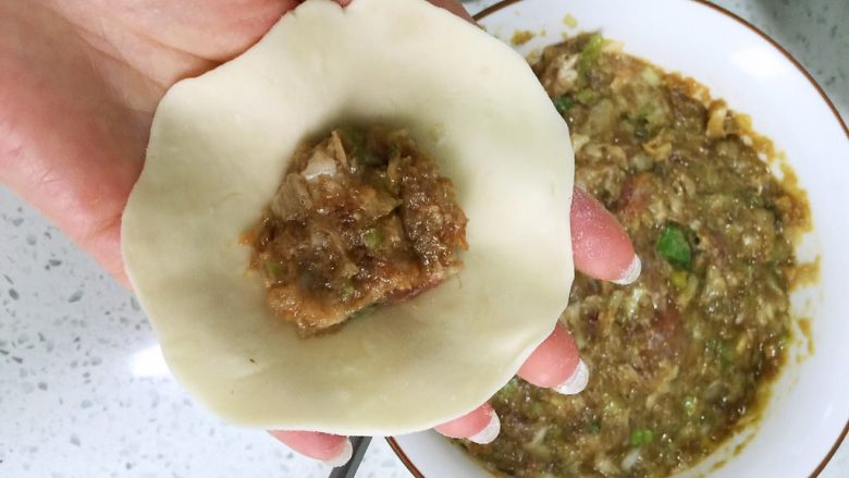 花式牛肉煎包,擀皮,先包牛肉馅,提四个角捏在一起,在空隙处塞上准备好的四种馅料,