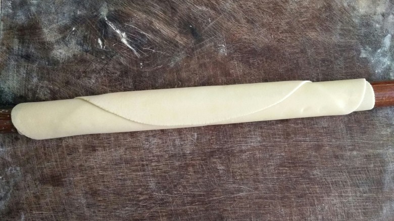 手擀面,用擀面杖擀成尽量薄的大面皮,圆形、长方形均可。用手摸摸看面皮厚度是否均匀,如果有较厚的部分,需用擀面杖将面皮擀成一致的厚度。