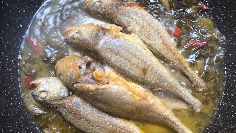 糟菜烧小黄鱼,放入小黄鱼,转中火炖10分钟