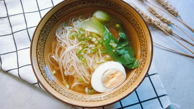 热气腾腾的阳春面,煮熟后捞入碗中,搭配半个<a style='color:red;display:inline-block;' href='/shicai/ 211807'>煮蛋</a>,撒些许葱花就可以开吃了。