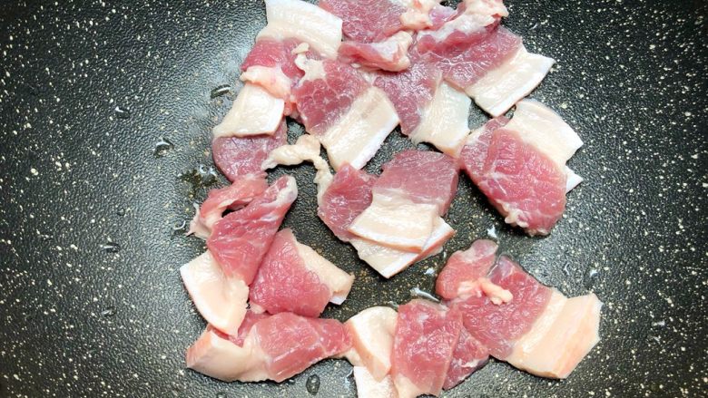 五花肉炒包菜,五花肉放入锅里,小火煸炒出油
