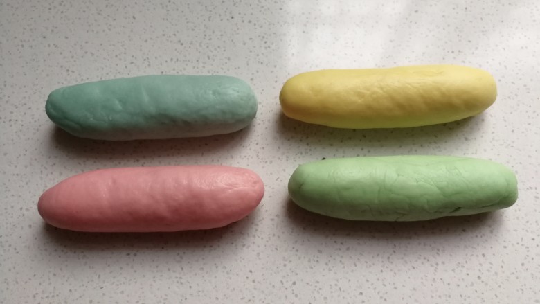 春之色~彩虹面包卷,发酵好的小面团取出来挤压排气,分别搓成长条状。