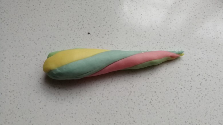 春之色~彩虹面包卷,再把四种颜色的面团扭转着滚圆搓紧,搓成更长的彩色水滴状