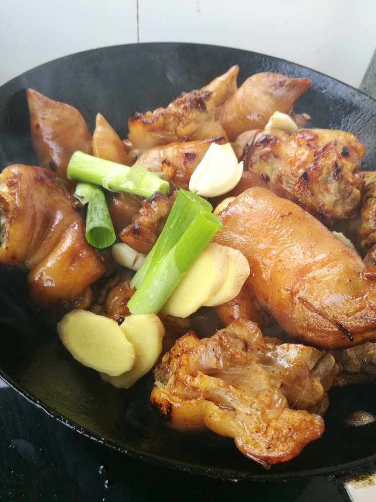 红烧猪蹄,再倒入葱姜蒜继续翻炒，直到闻到香味。