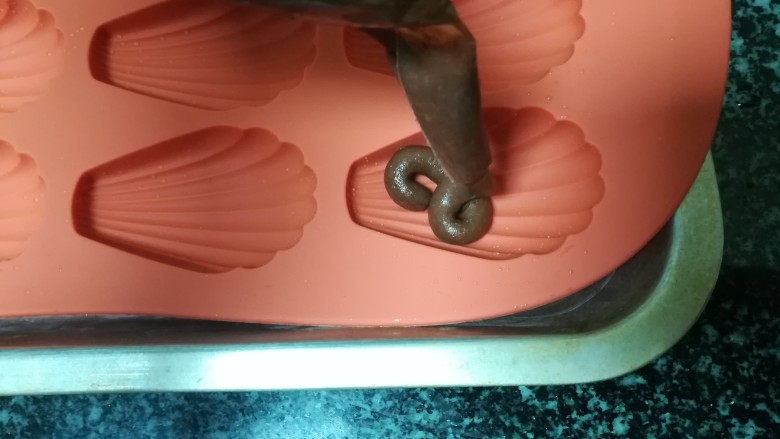 神奇的玛德琳,挤，我挤，挤挤，每个模具挤满8分左右。
因为第一次做没有经验，我挤太满了，但真的很好看，小模样非常完美，这点等下就可以看出来了。
